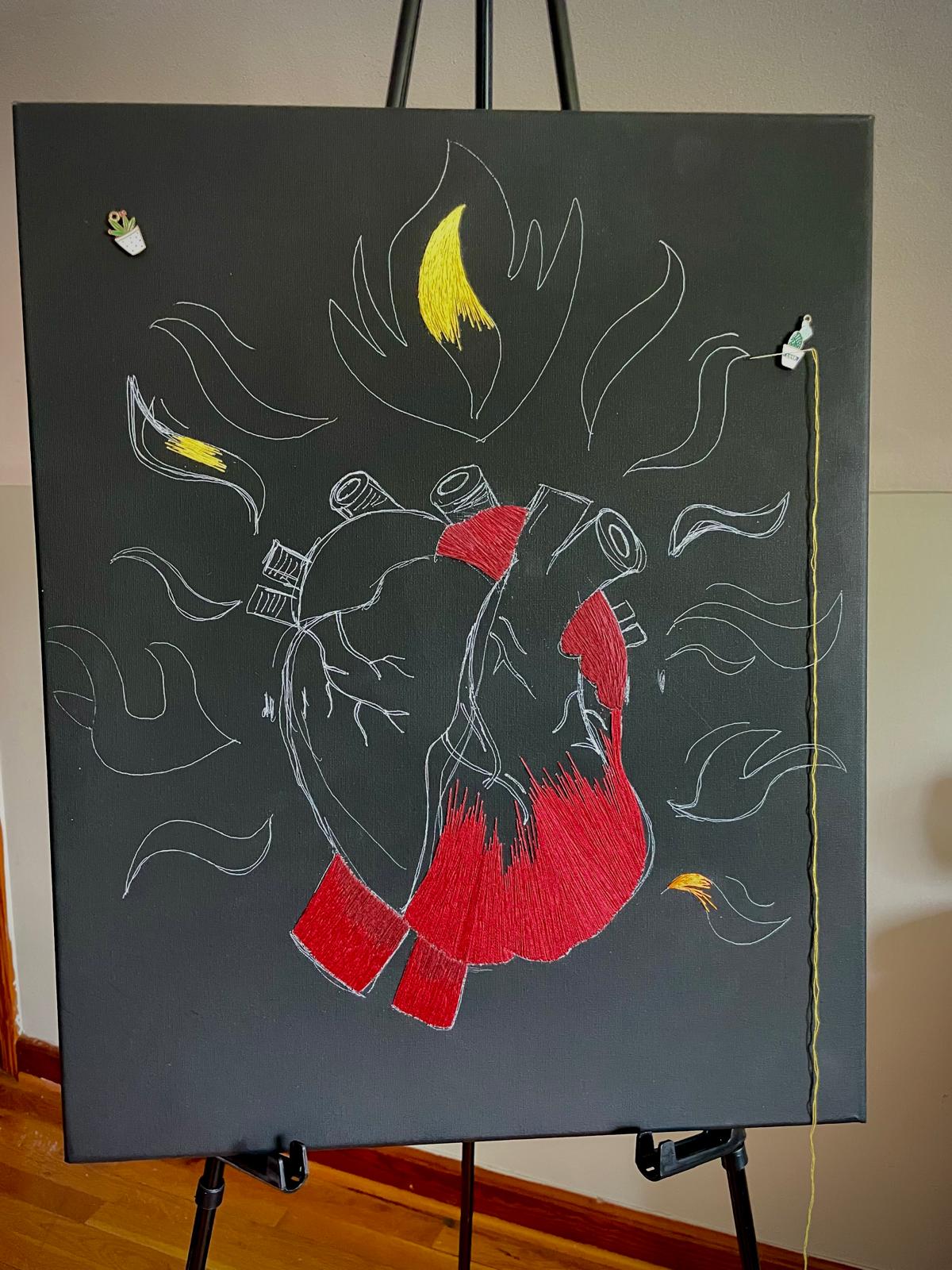 Chalk drawing of a human heart with flames and abstract lines on a blackboard.