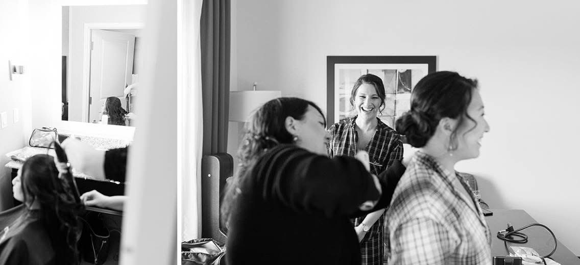 Four women in a room, two sitting and two standing, smiling and talking, with a mirror and framed picture in the background.