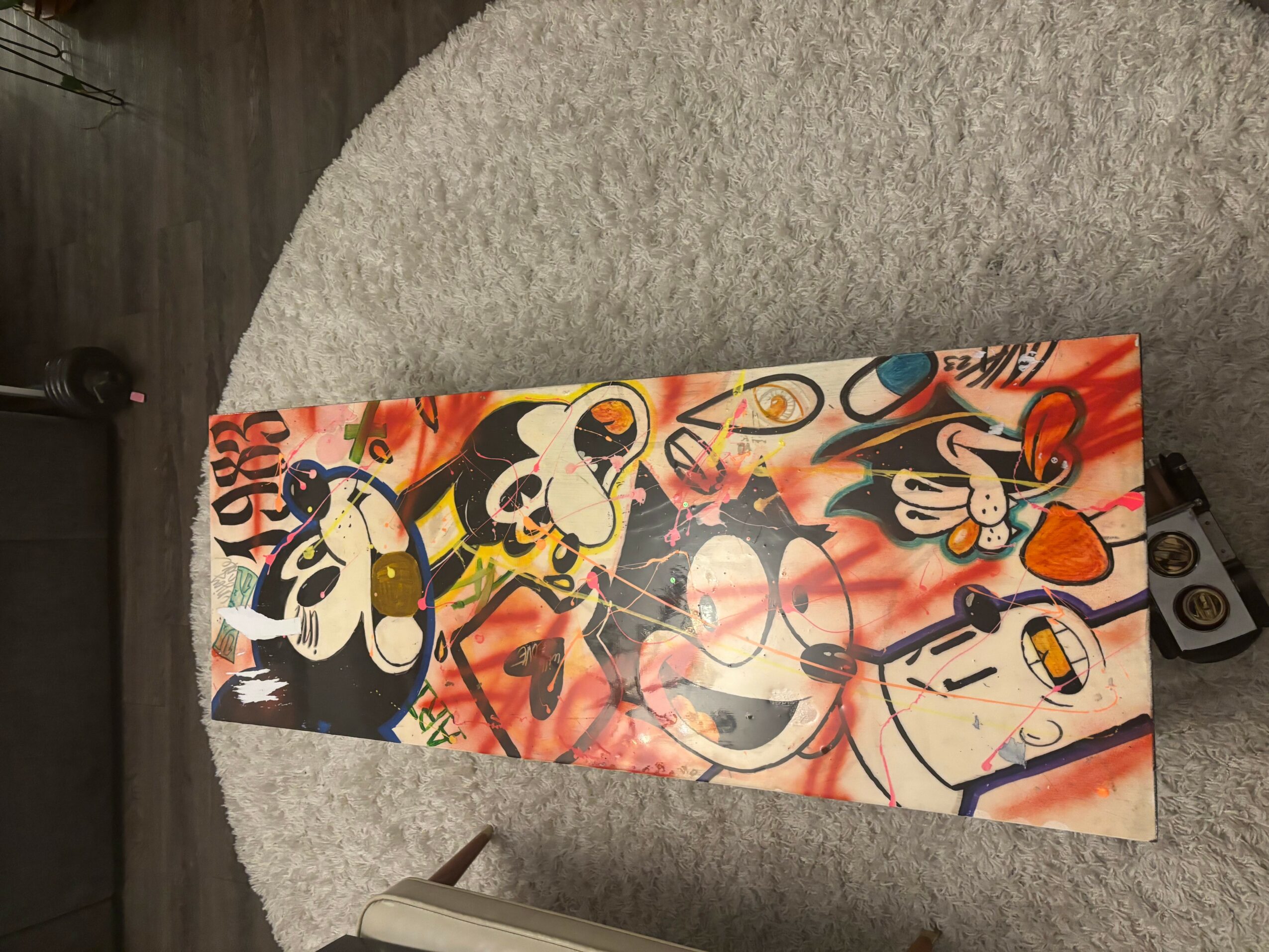 Vertical colorful artwork featuring cartoon characters with exaggerated expressions and various objects, on a rectangular canvas.