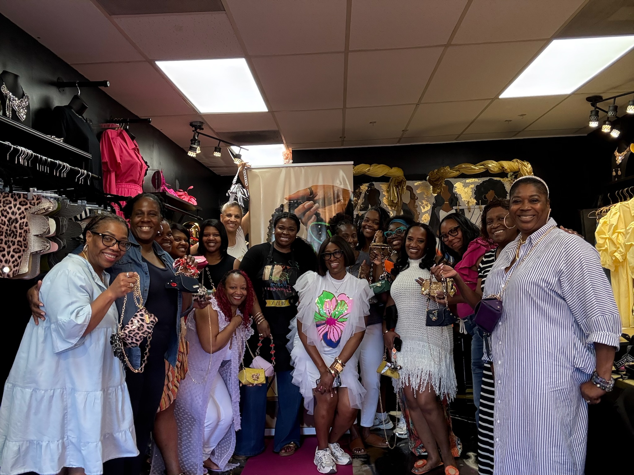 Group of people smiling and posing inside a store with clothing displays and bright lighting.