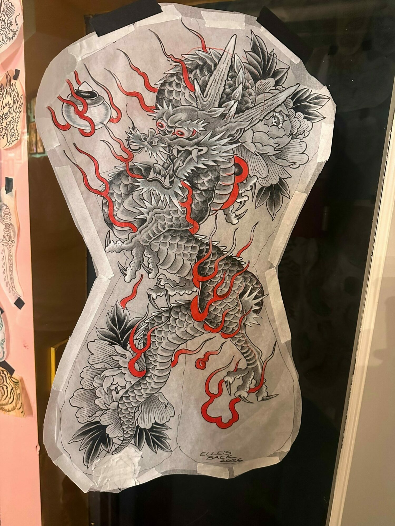 Black and white dragon with red accents on paper, detailed scales and flowing mane, appears to be traditional Asian art.