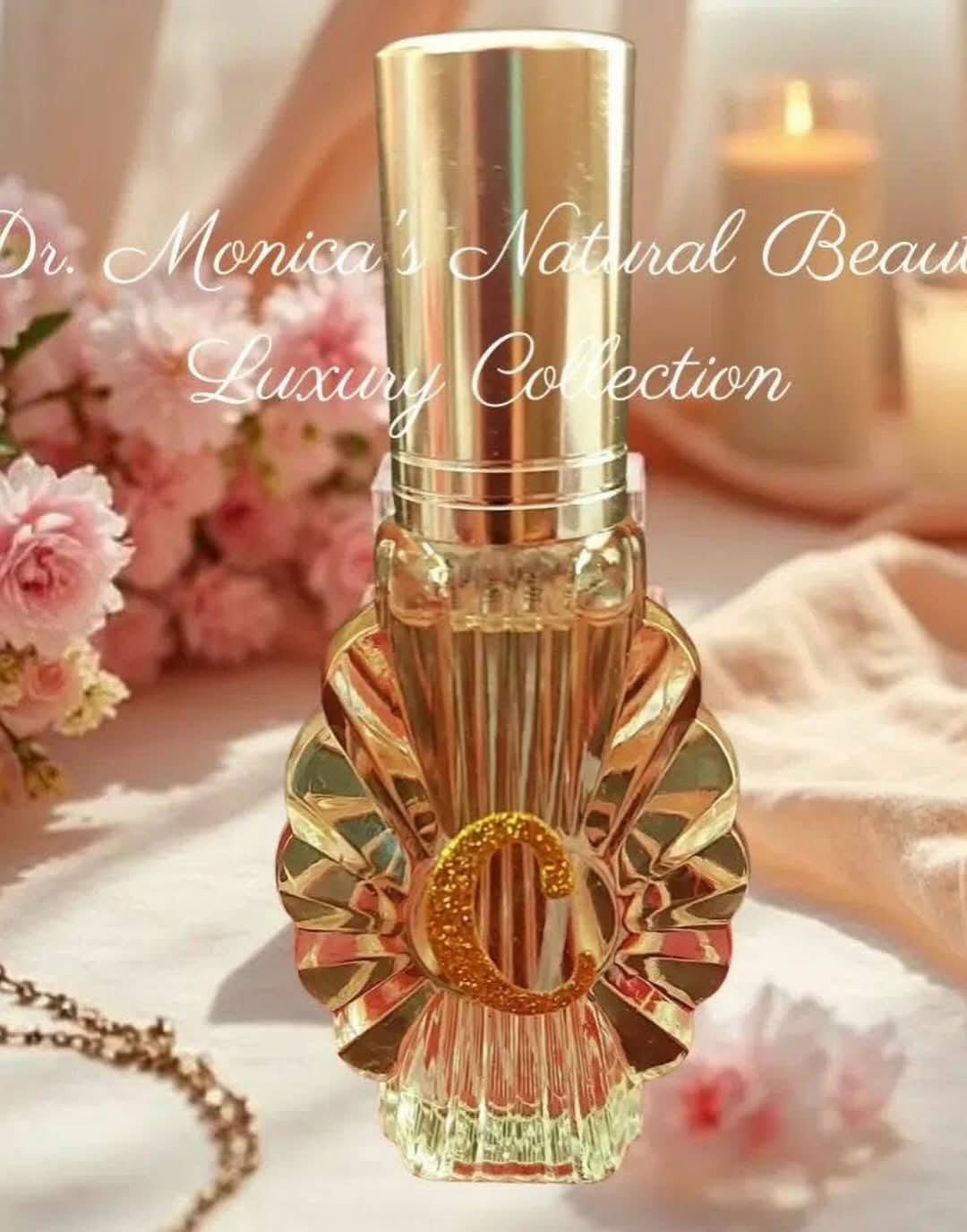 A gold and clear perfume bottle with a decorative gold emblem, set on a soft fabric with flowers and candles in background.