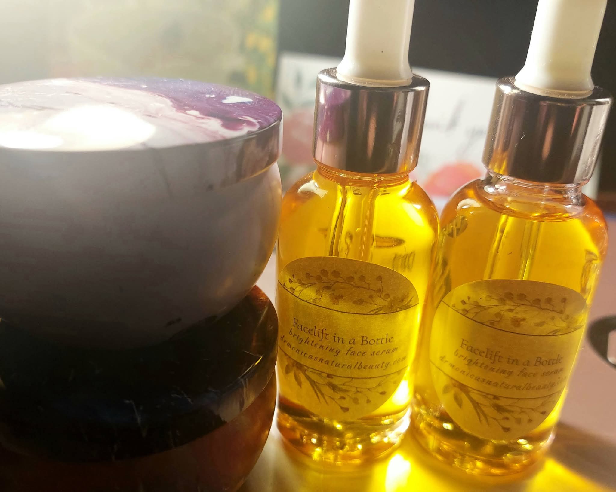 Two small bottles filled with yellow liquid and white droppers, and a bowl with a purple and white pattern, on a surface.