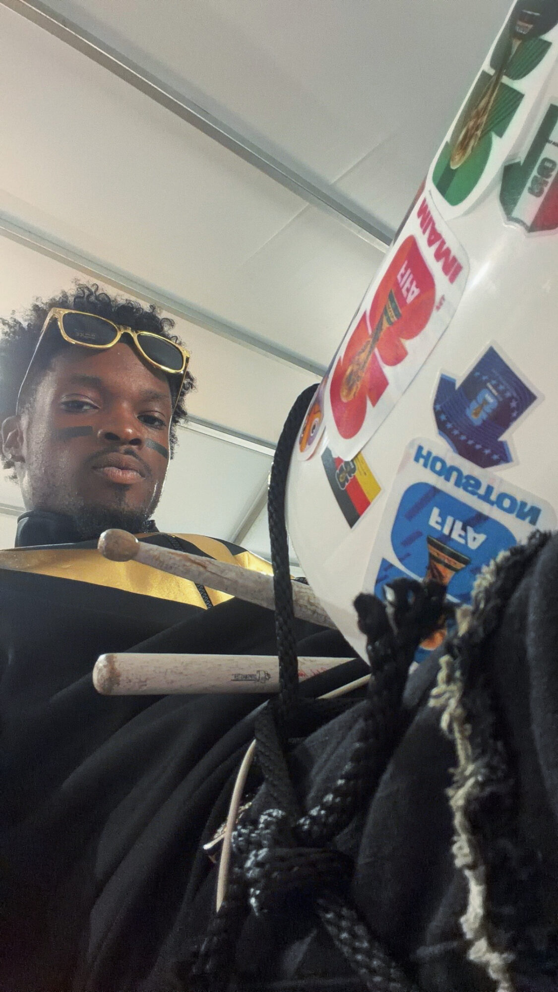 Person with sunglasses on head looking at camera, store shelves with various products in background.