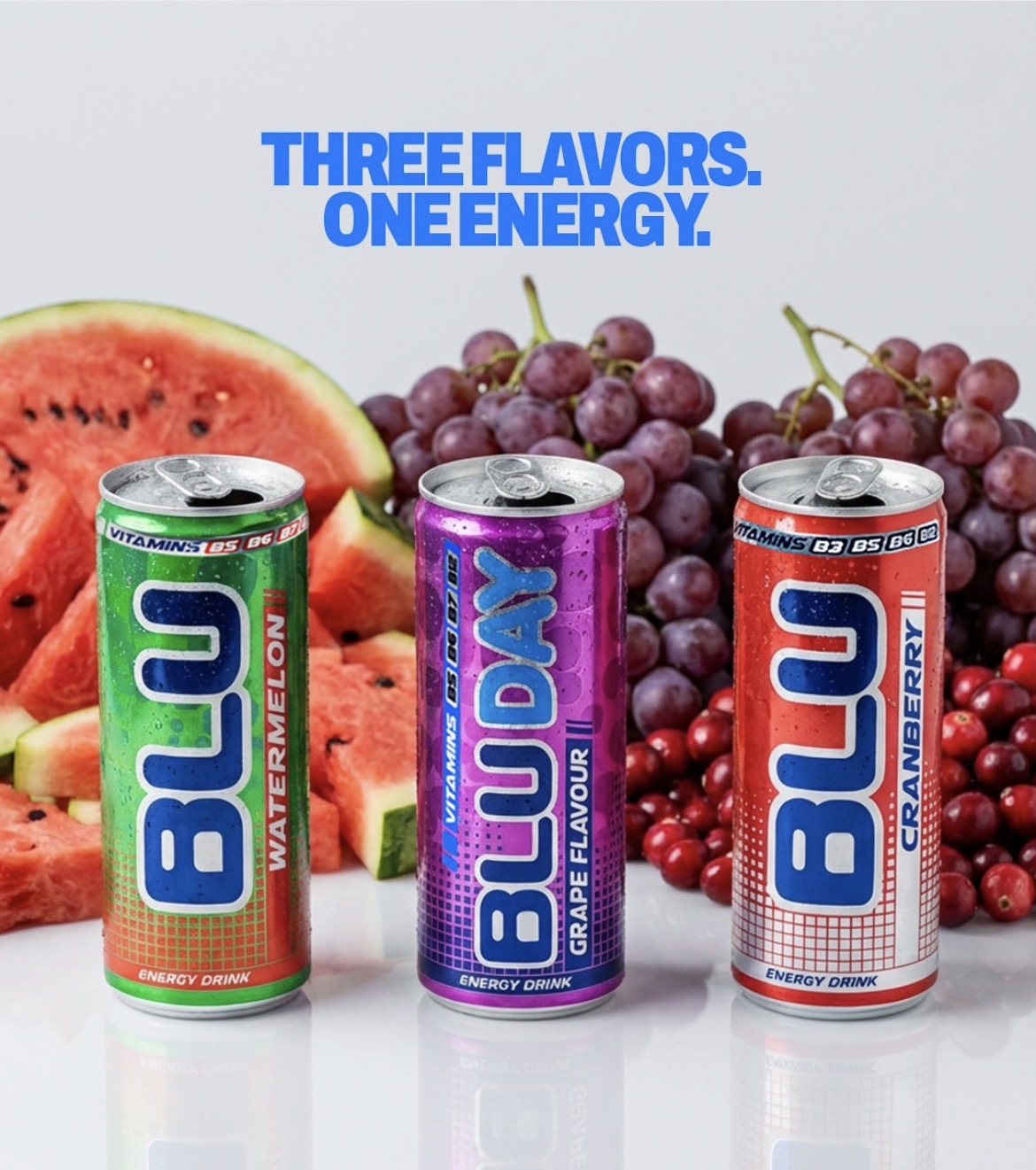 Three cans of energy drink with watermelon, grape, and cranberry flavors, with fruit images in the background, and blue text above.