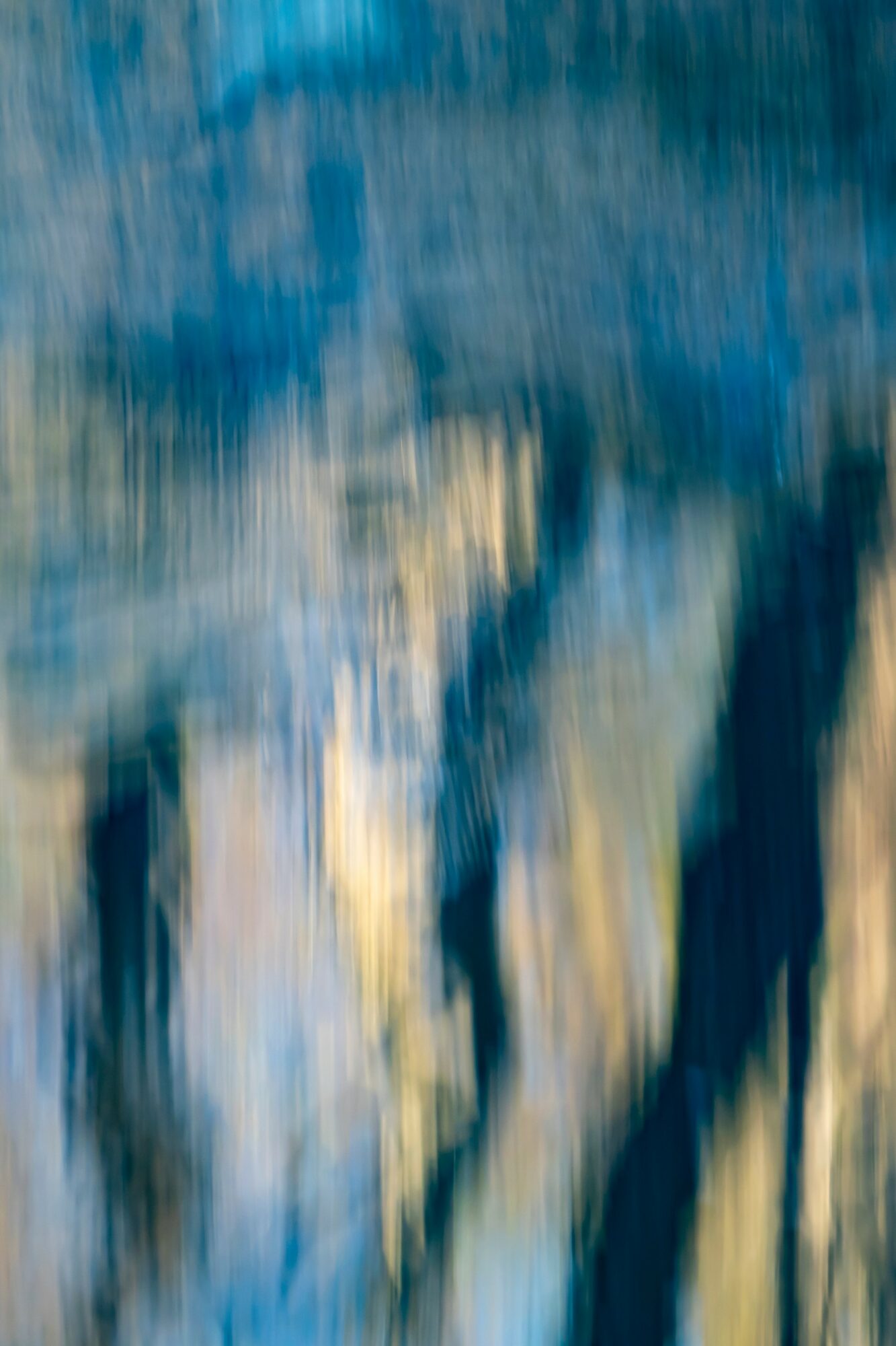 Abstract blurred image with blue, beige, and dark colors, resembling a painting or reflection.