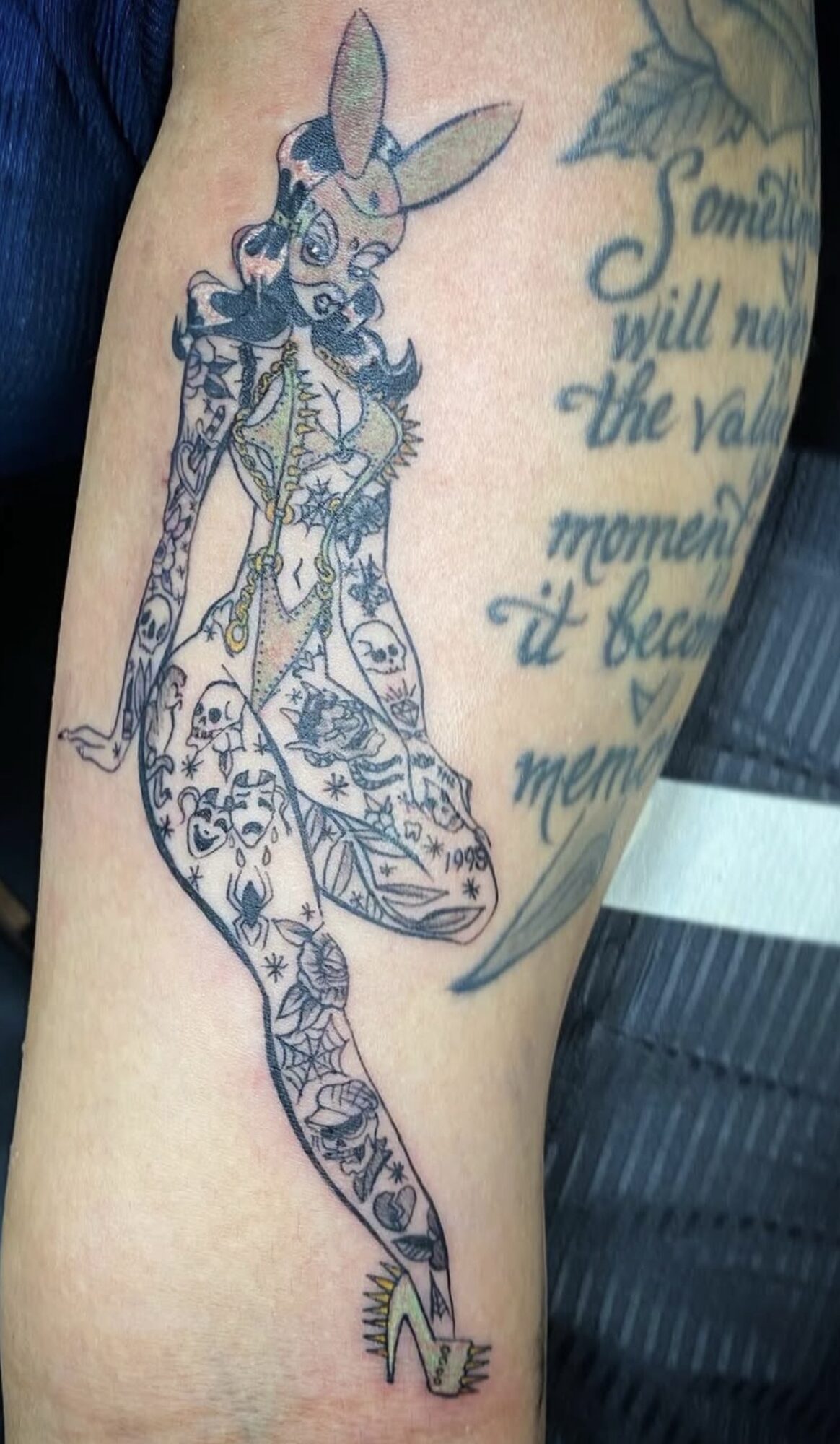 Tattoo of a stylized rabbit with floral and decorative patterns, wearing high heels, on a person's arm.