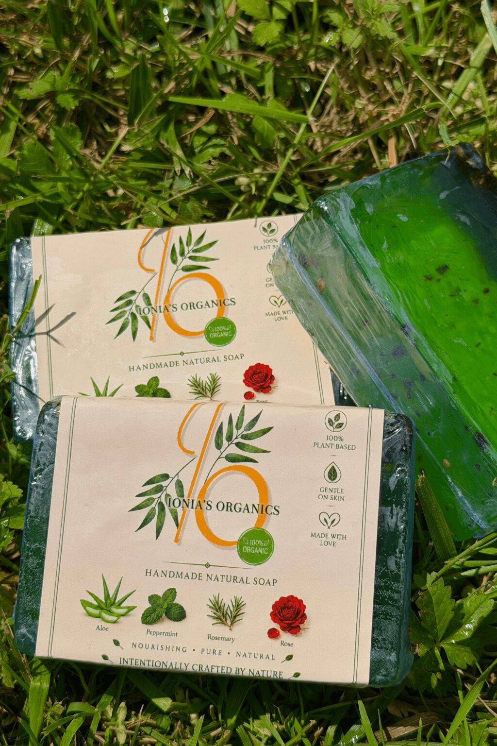 Two soap boxes placed on grass, with one box partially open, showing green soap inside.