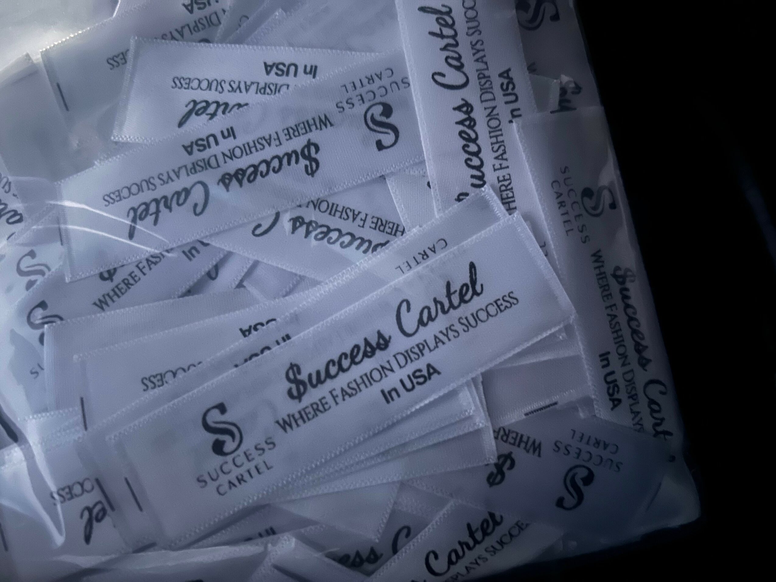 Multiple transparent plastic bags with printed text, stacked and overlapping, containing business cards or similar items.