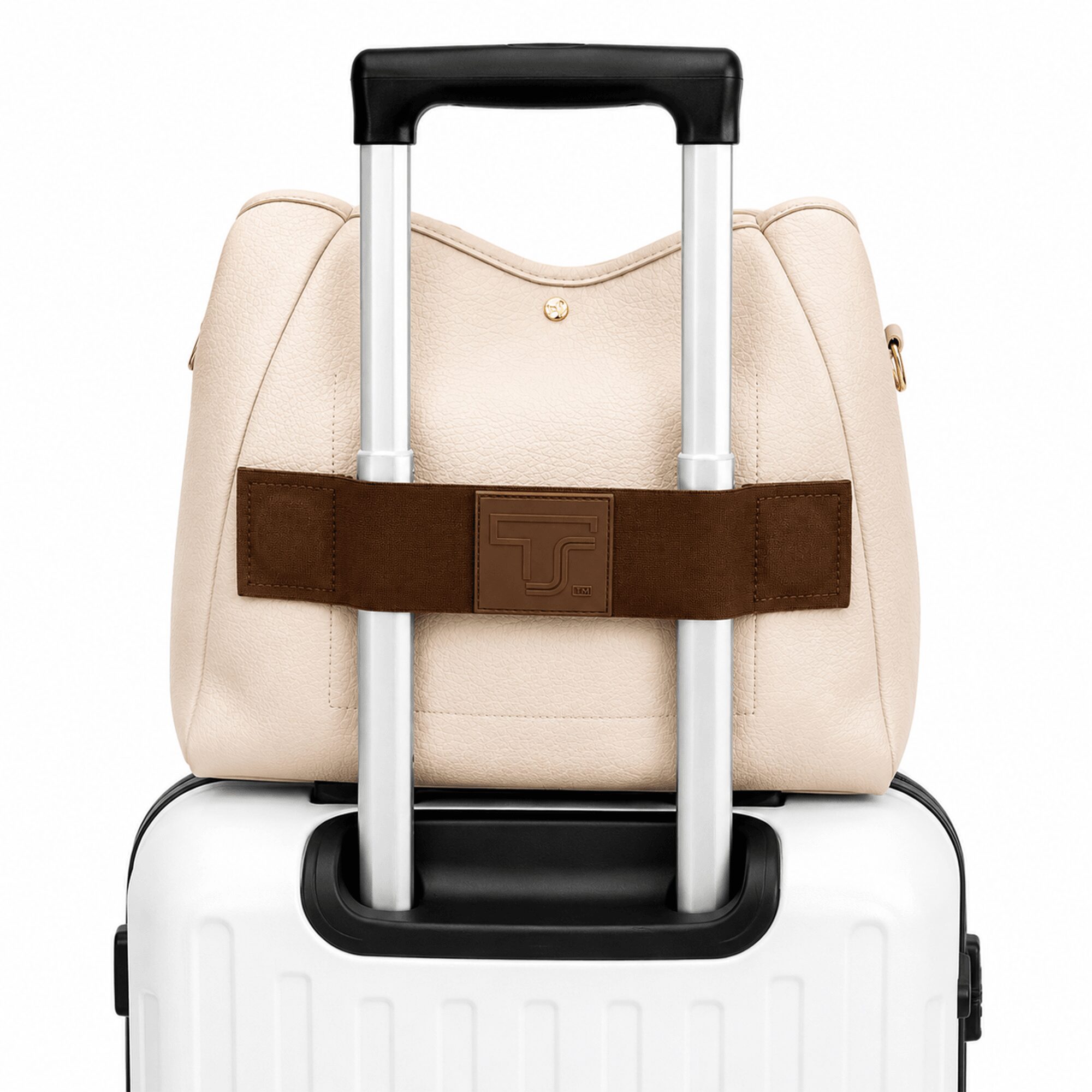 A beige handbag with a brown strap on a white suitcase with a black handle, against a plain background.
