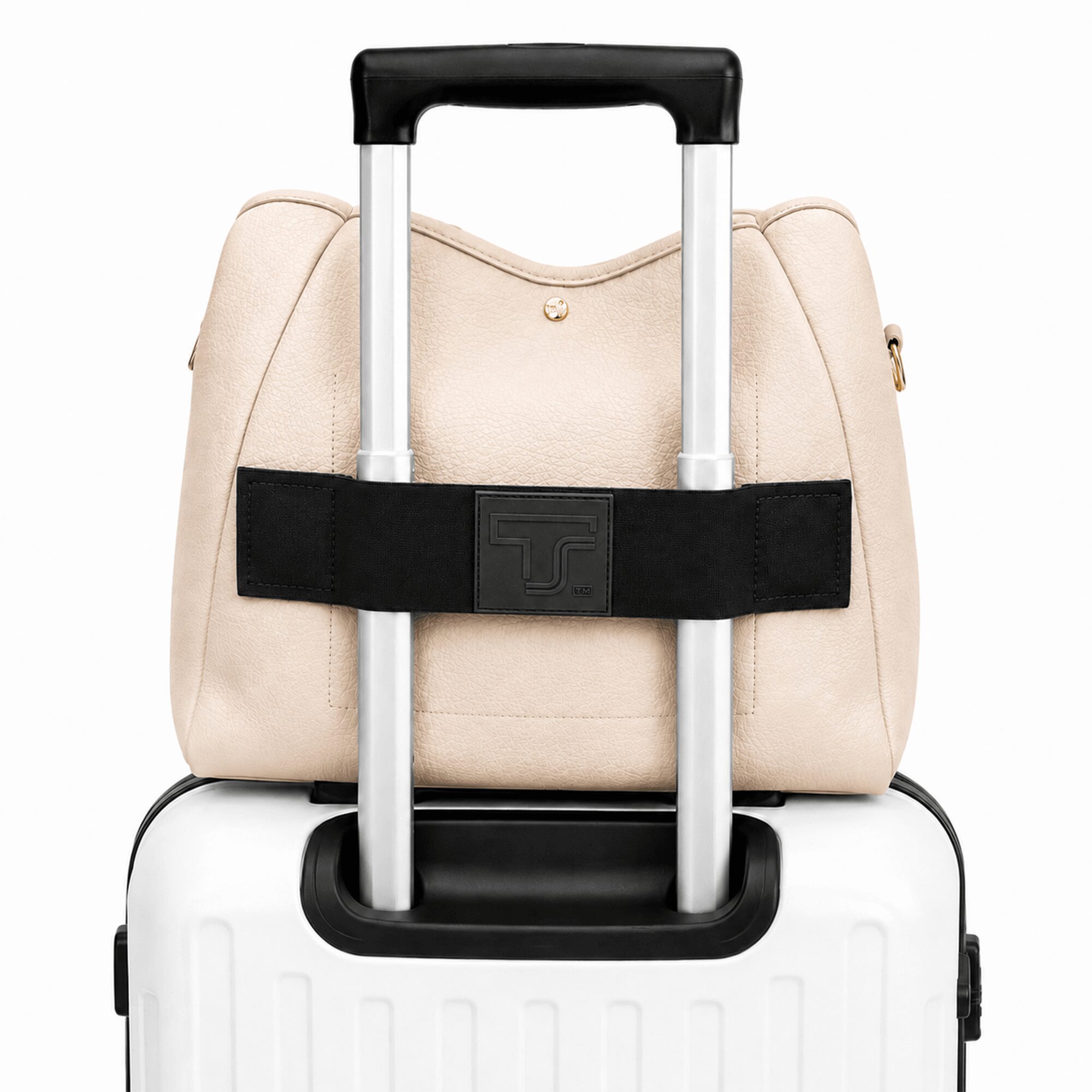 A beige handbag with a black strap and a small gold emblem, placed on a white suitcase with a black handle.