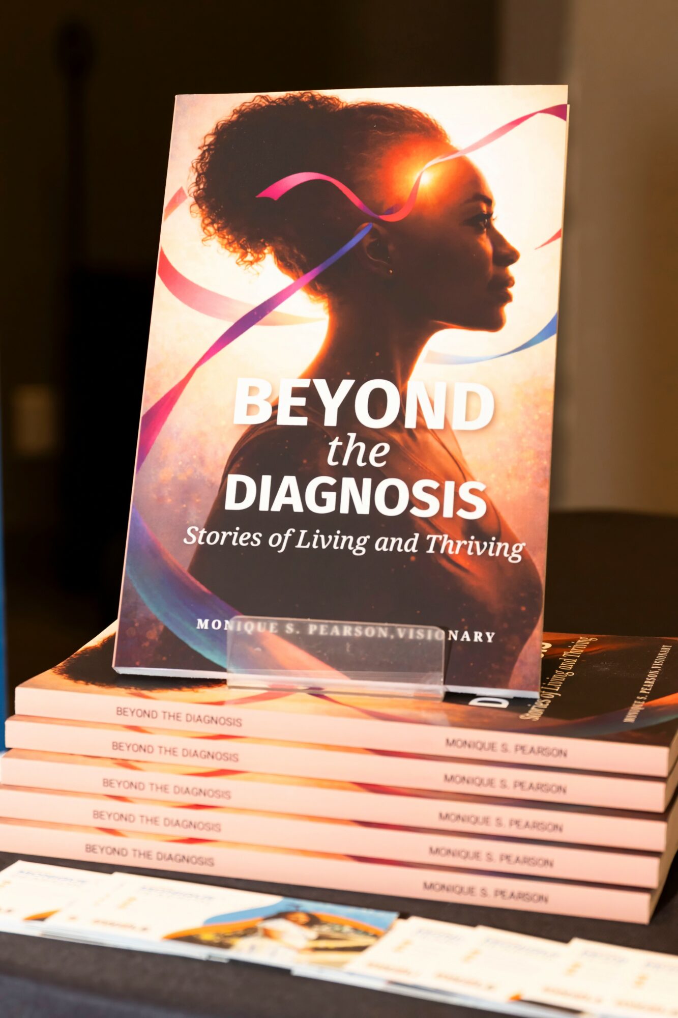 Book titled 'Beyond the Diagnosis' with a silhouette of a woman with natural hair, standing in profile, on the cover.