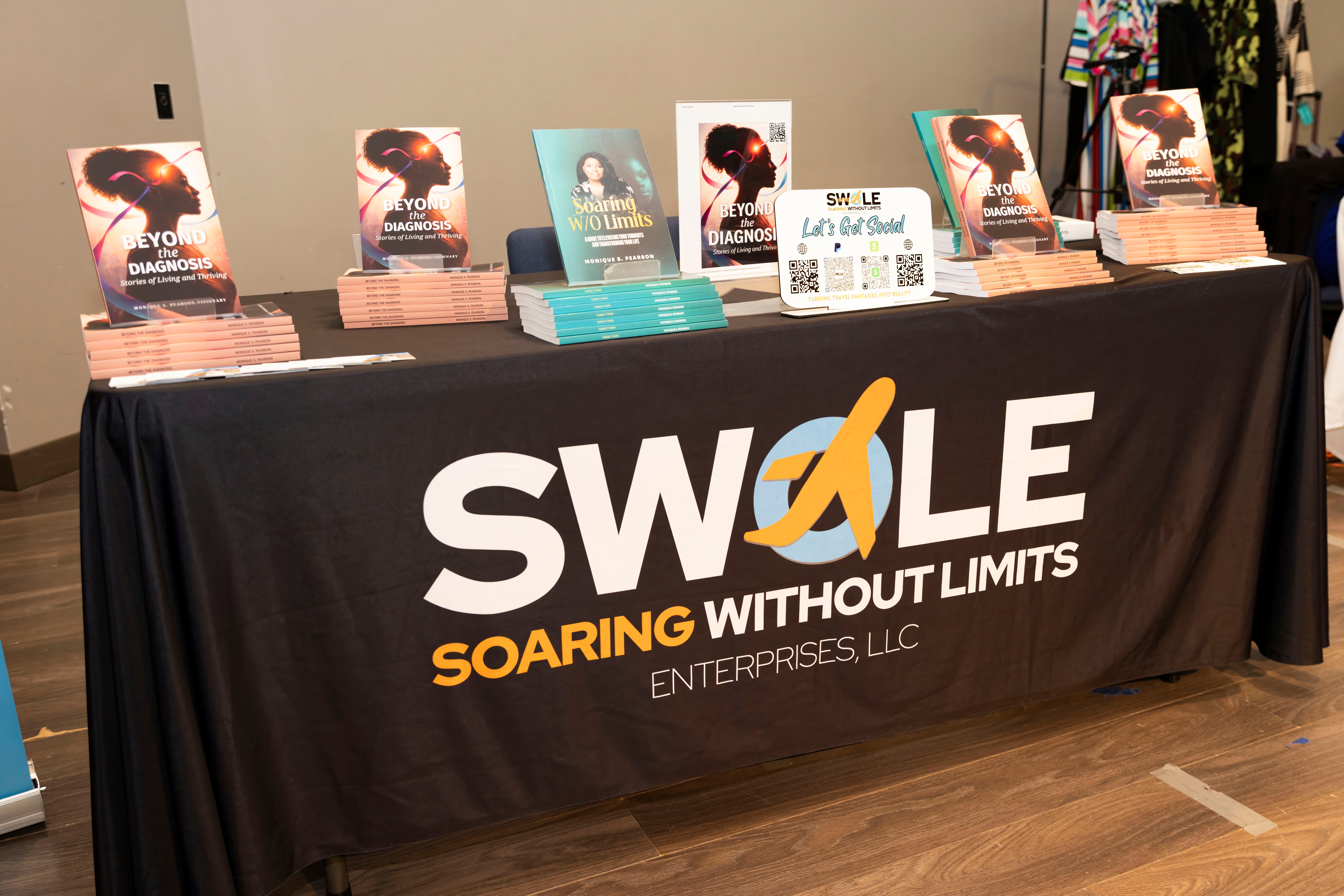 Table with promotional materials and books, displaying the SWALE logo and slogan, in an indoor setting.