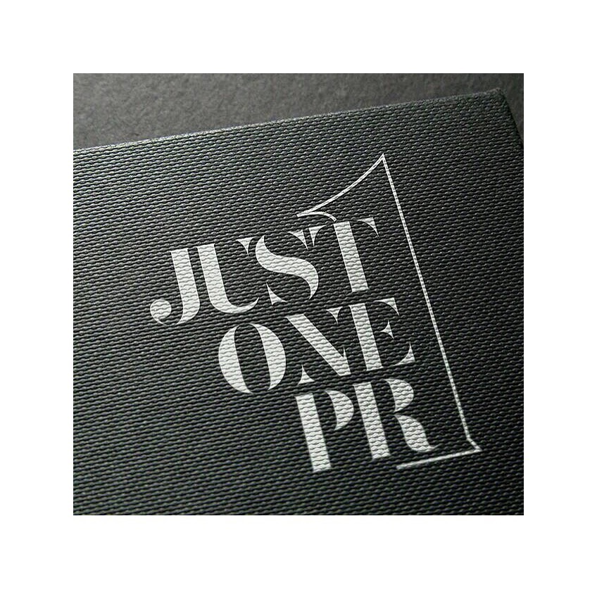 Close-up of a textured black surface with white text reading 'JUST ONE PR'.