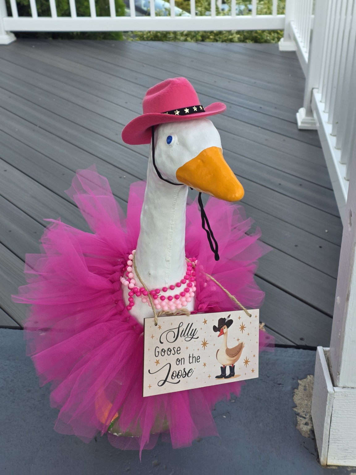 Decorated goose puppet with pink hat, tutu, and pearl necklace, holding a sign that reads 'Silly Goose on the Loose'.