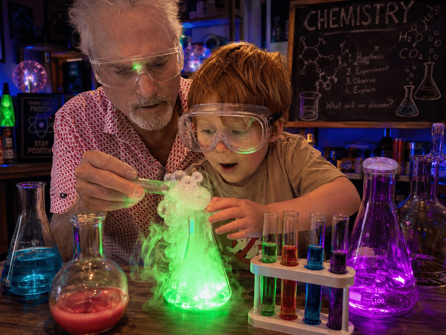 Adult and child conducting a science experiment with glowing green substance in a laboratory setting.