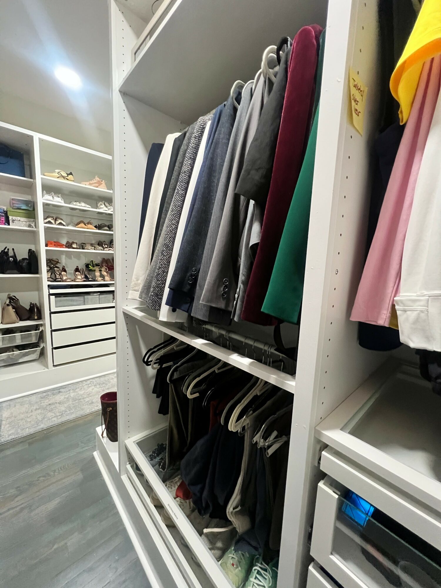 Shelf with folded clothes and papers, viewed from the side, with a floor and other shelves visible.