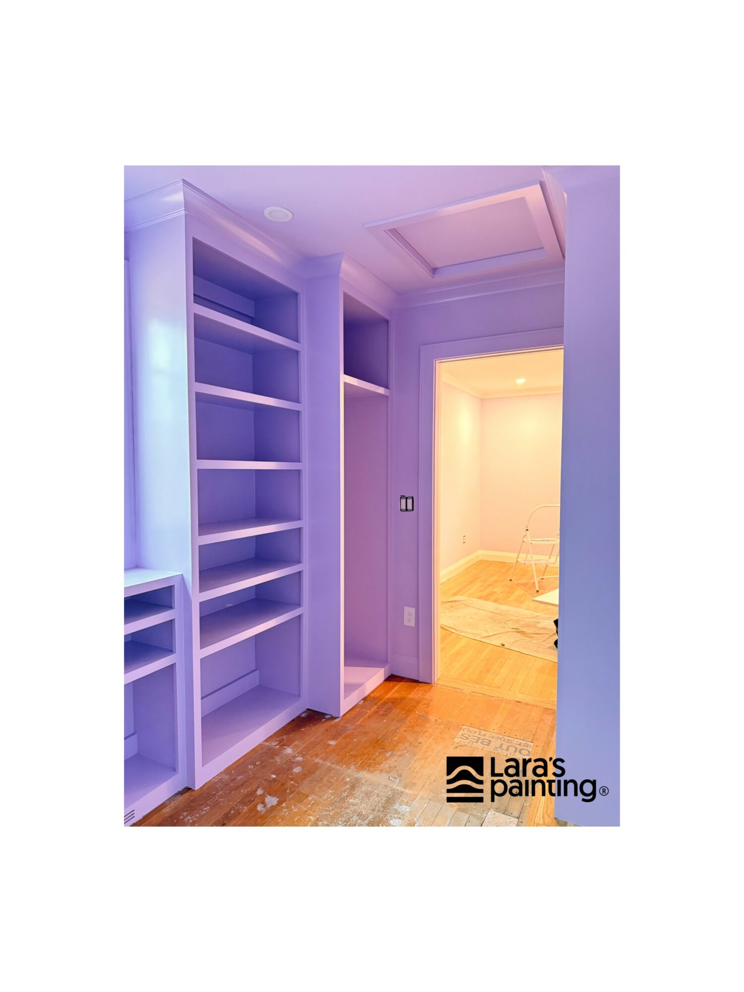 Empty built-in bookshelf with multiple shelves in a room, doorway leading to a brightly lit space, wooden floor, and ceiling light fixture.