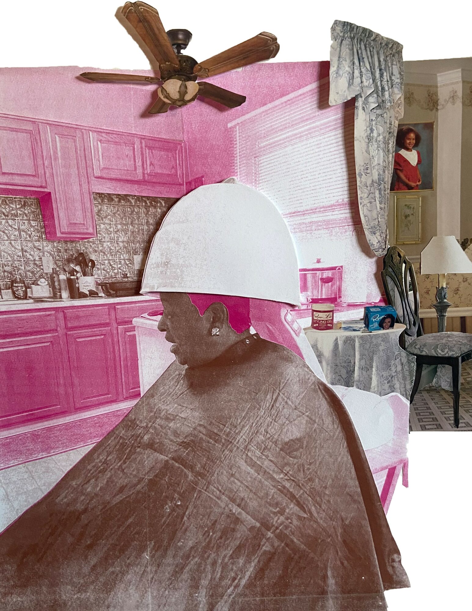 Person with a white hat and cape sitting in a room with pink kitchen cabinets and a ceiling fan.