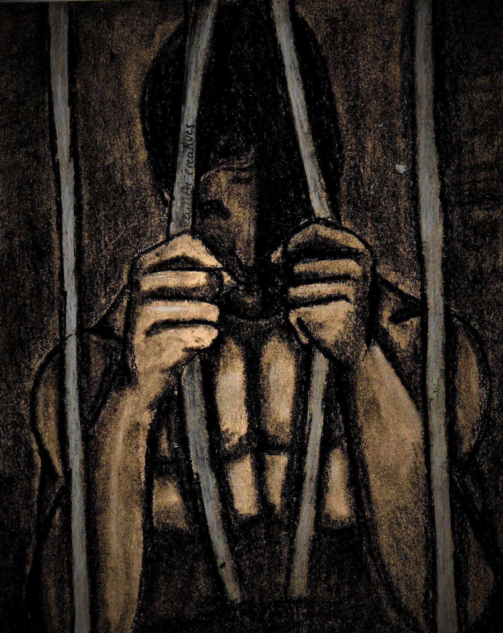 Person behind bars holding their hands to their face, with a dark background and barred window or door.