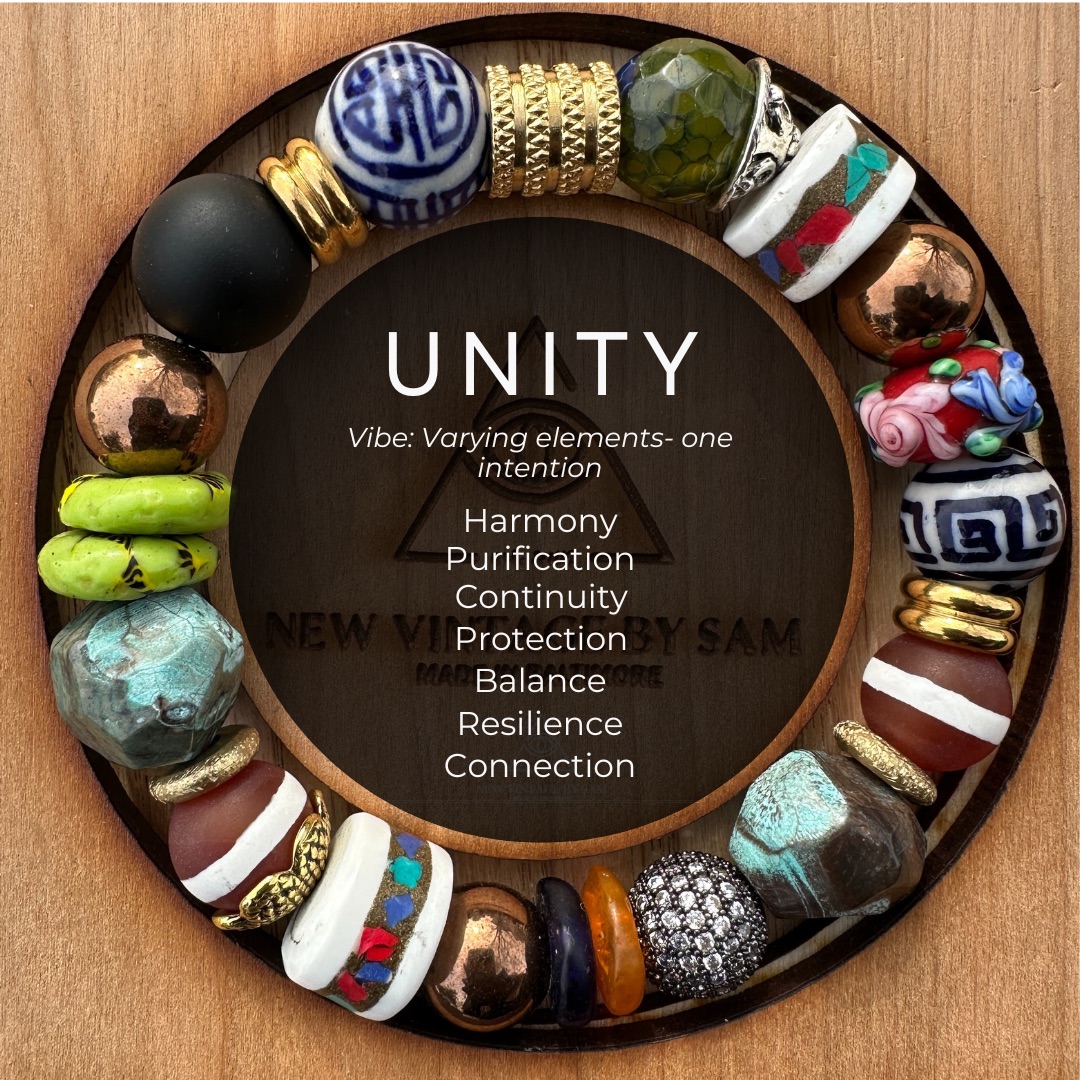 Decorative circular arrangement of various beads surrounds a wooden center with the word 'UNITY' and related words.