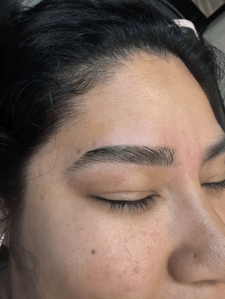 Close-up of a woman's face with closed eyes, showing well-groomed eyebrows and clear skin.