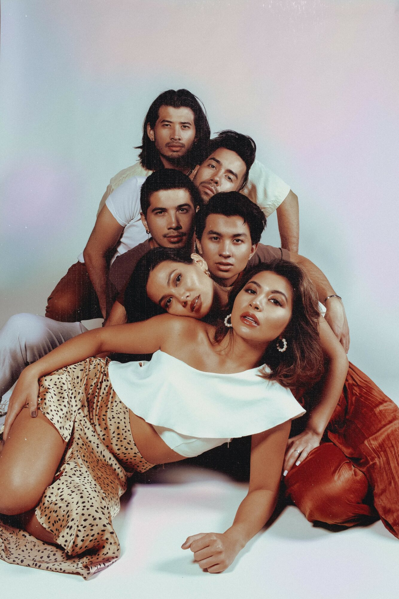 Group of six people, five men and one woman, posing together against a plain background.
