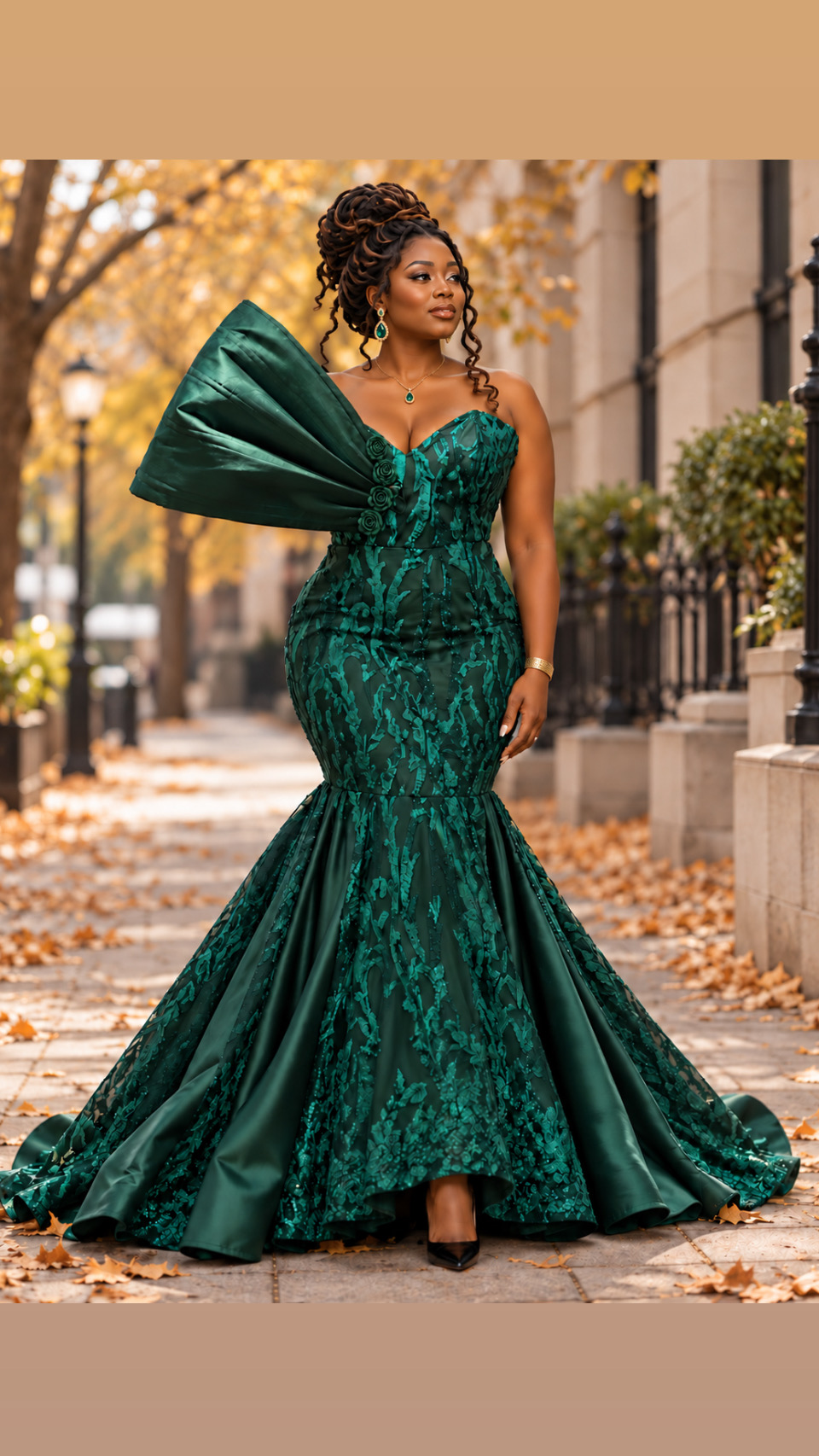 Woman in a green, strapless, floor-length gown with large bow detail on shoulder, standing outdoors with autumn leaves.