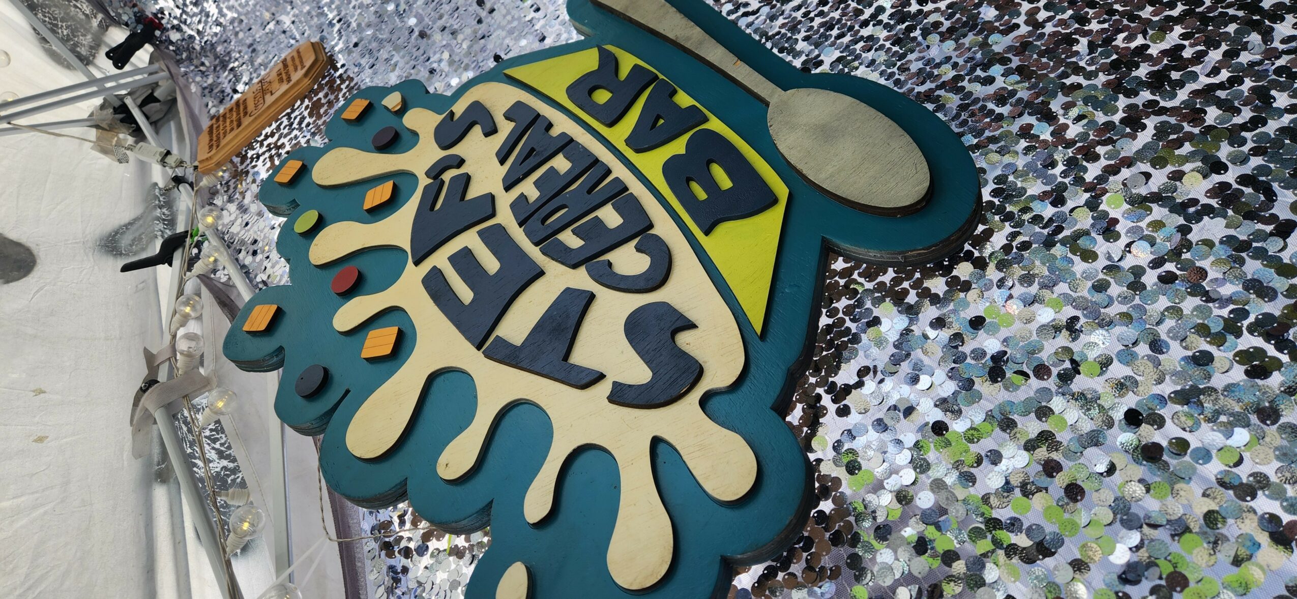 Sign with text 'STAY SAFE' and 'BEAR' on a colorful, patterned background.