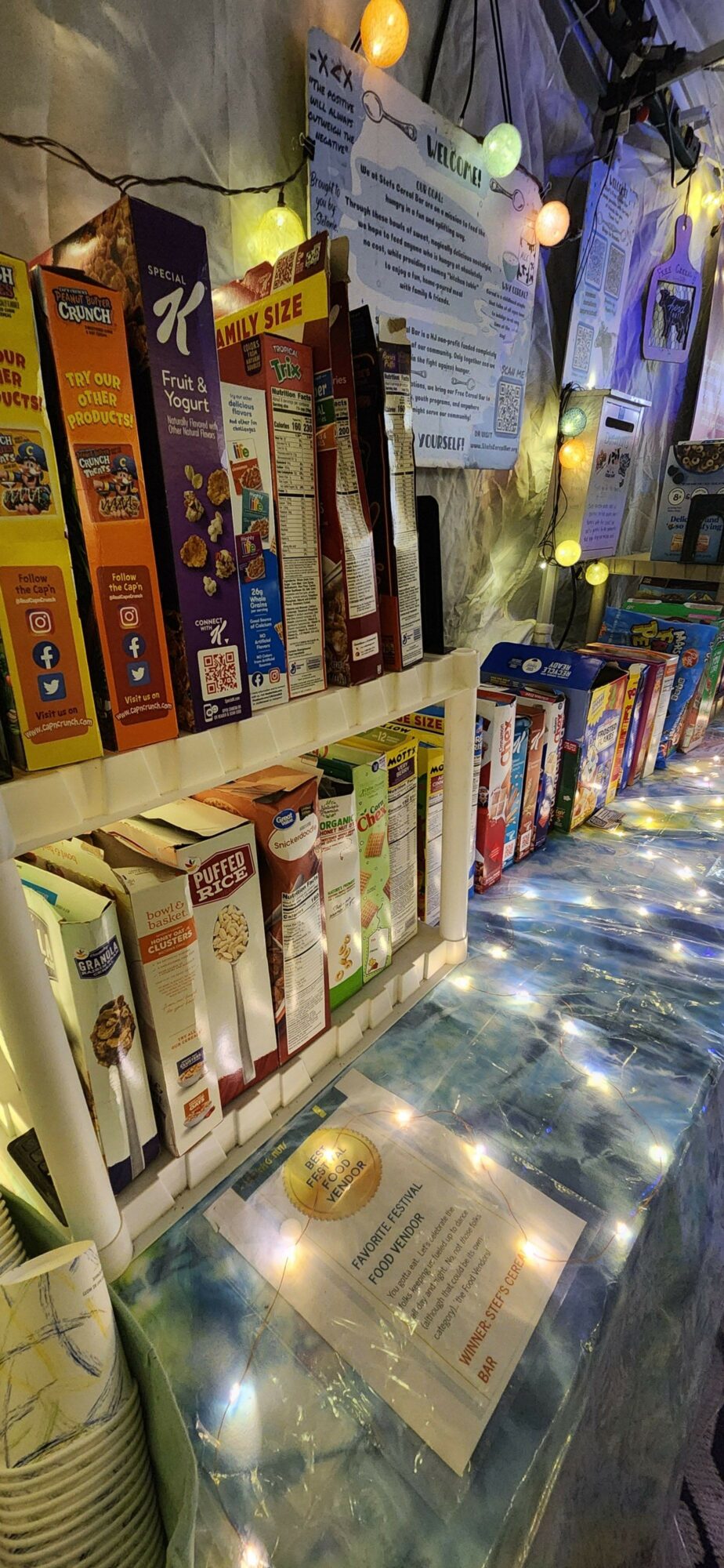 Display of various chocolate bars and snacks on a table with lights and promotional materials.